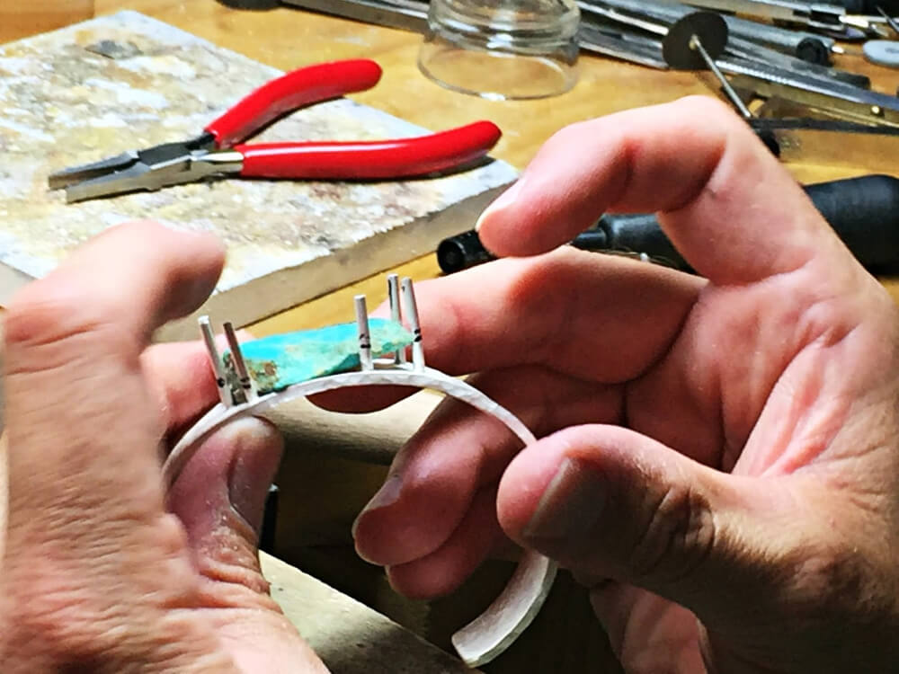 setting a turquoise stone in a silver cuff bracelet